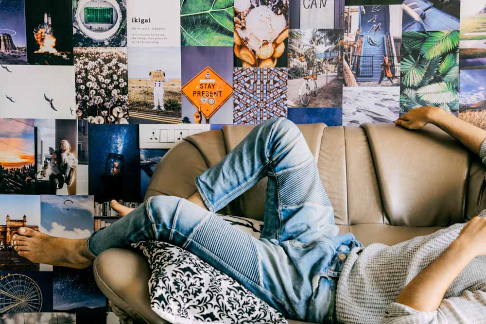 Aesthetic cozy blue posters collage on a wall behind a couch