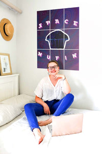 Short hair girl working on bed with muffin block kit poster behind her on the wall