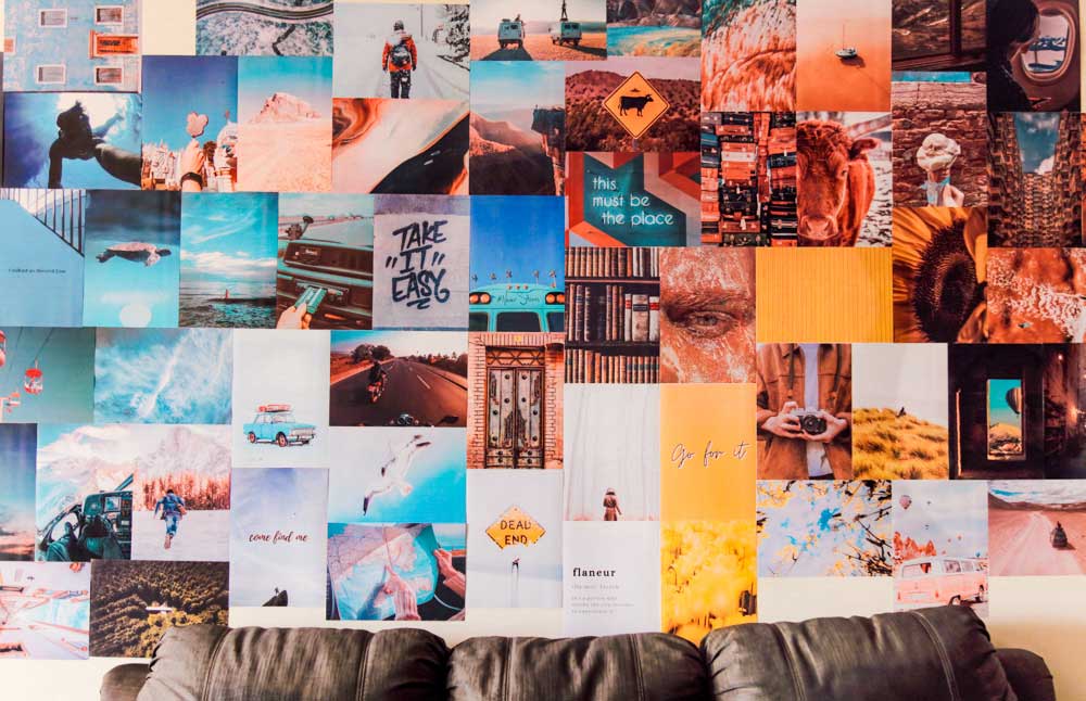 Colorful travel posters collage on a wall over a black couch